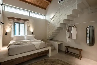 a bedroom with a bed and a staircase at Olive Hideaway Private Pool Villa, Chania Sleeps 7 in Kalamitsi Amygdali