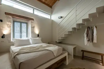 a bedroom with a bed and a staircase at Olive Hideaway Private Pool Villa, Chania Sleeps 7 in Kalamitsi Amygdali