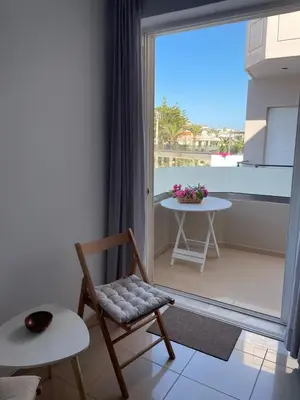 a room with a chair and a table and a window at Cielo y Sol in Stalos