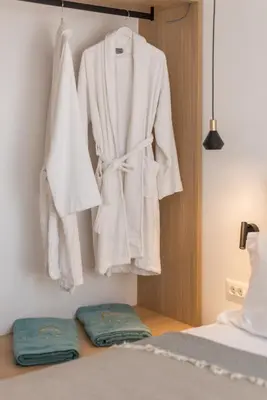 a robe hanging on a wall next to a bed at Neapolis in Chania Town