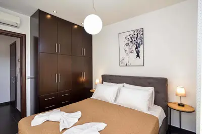 a bedroom with a large bed with brown cabinets at Arieldine Luxury Apartment in Chania Town