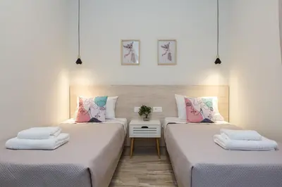 two beds in a room with white walls at Yume Luxury Home in Pírgos