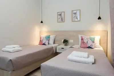 two beds in a small room with white and pink at Yume Luxury Home in Pírgos