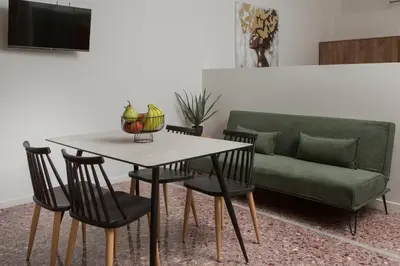 a living room with a table and a green couch at Fyllianos Apartments in Plátanos