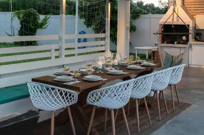 a wooden table with chairs and wine glasses on a patio at Myrto Villa heated pool in Kato Daratso