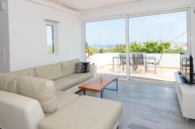a living room with a couch and a table at Myrto Villa heated pool in Kato Daratso