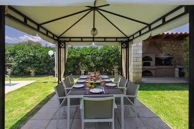 a dining table under a tent in a backyard at Villa Clio, with Mountain view in Arménoi