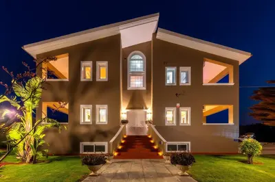 a large house with a front entrance at night at Villa Clio, with Mountain view in Arménoi