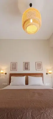 a bedroom with a large bed and a chandelier at Lithos in Palaiochóra