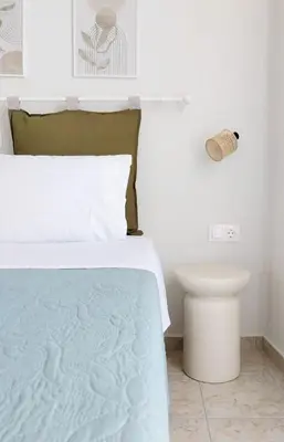 a white bedroom with a bed and a toilet at Lithos in Palaiochóra