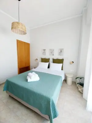 a bedroom with a bed with a green bedspread at Lithos in Palaiochóra