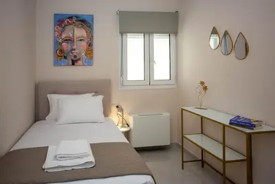 a bedroom with a bed and a painting on the wall at Maira City House in Chania Town