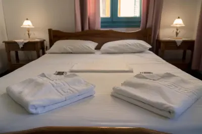 two towels are sitting on a white bed at Pension Nora in Chania Town