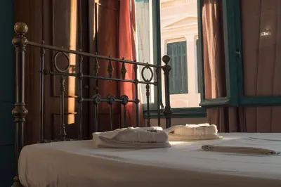 a bed with two towels on top of it at Pension Nora in Chania Town