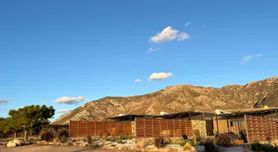 a brick building with a mountain in the background at LIViT Condo Elafonisi in Agios Padeleimon