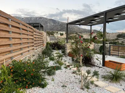 a garden with a fence and some flowers at LIViT Condo Elafonisi in Agios Padeleimon