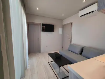 a living room with a blue couch and a table at LIViT Condo Elafonisi in Agios Padeleimon