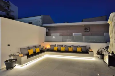 a bench with yellow pillows on the side of a building at Artemis Luxury Home in Chania Town