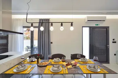 a dining room with a table with plates and wine glasses at Artemis Luxury Home in Chania Town