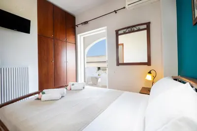 a bedroom with a large bed and a mirror at Nektar Luxury Apartment in Stalos