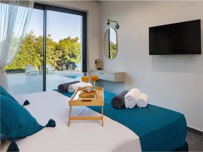 a living room with a bed and a tv at PanStel - Villa Aurora with private pool jacuzzi in Ayiá