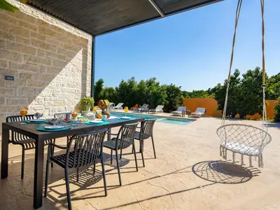a table and chairs on a patio with a pool at PanStel - Villa Aurora with private pool jacuzzi in Ayiá