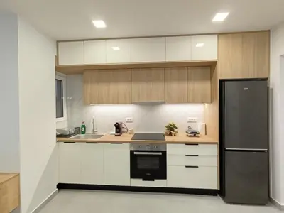 a kitchen with white cabinets and a black refrigerator at MC Luxury Living in Chania Town