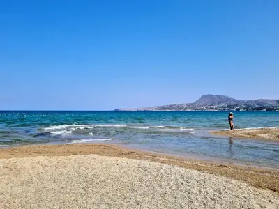 a person standing in the water on a beach at Hidden Gem at Kiani Beach in Kalyves