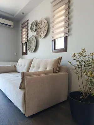 a living room with a couch and plates on the wall at Reflections Apartments in Stalos