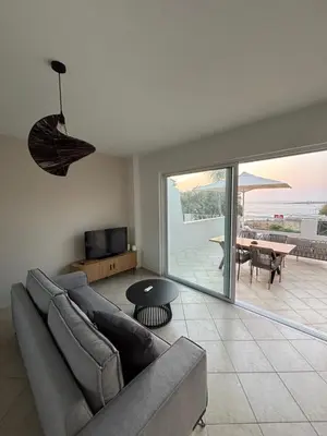 a living room with a couch and a view of the ocean at Nea Chora seaside suites in Chania Town