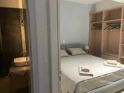 a small bedroom with a bed with white sheets at Nea Chora seaside suites in Chania Town