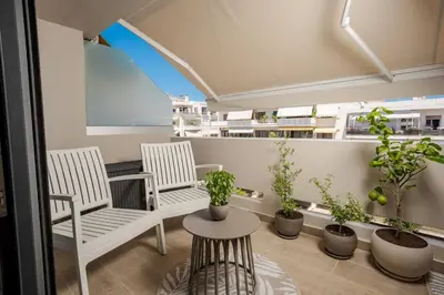a balcony with two chairs and potted plants at Kira Elegant City Nest in Chania Town