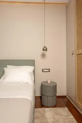 a bedroom with a bed and a table with a candle at Demmi Central 2BR Designer Apt in Chania Town