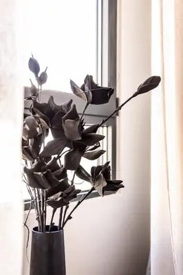 a black vase with a plant in a window at Demmi Central 2BR Designer Apt in Chania Town