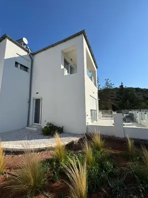 a white house with plants in front of it at Villa & Apartament Armonia 4 Gaia Vita Gavalochori-Vamos KRETA in Vamos