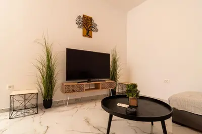 a living room with a flat screen tv on a wall at Casa calma! in Kountoura Selino