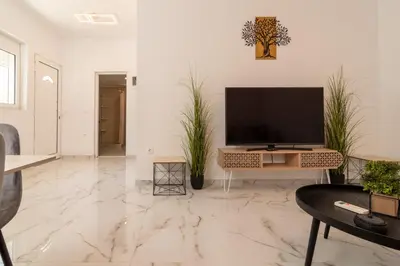 a living room with a television on a white wall at Casa calma! in Kountoura Selino
