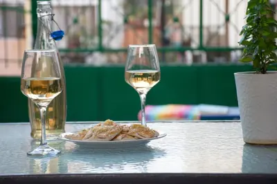 a table with a plate of food and two glasses of wine at Depi's Home in Kissamos