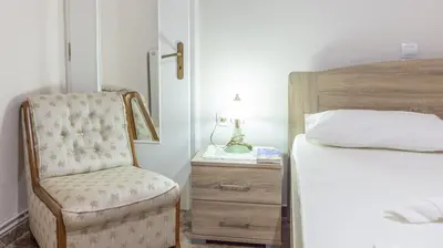a bedroom with a bed and a chair and a nightstand at Depi's Home in Kissamos