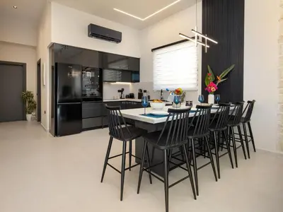 a kitchen with a table and black chairs at PanStel - Villa Solene with private pool in Ayiá