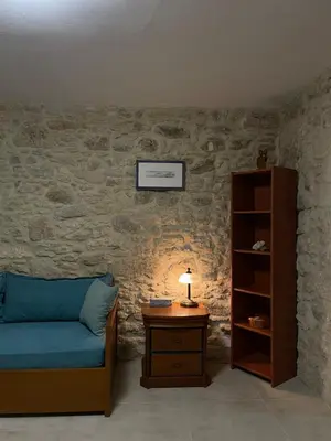 a bedroom with a bed and a table with a lamp at Casa Maria in Gramvousá