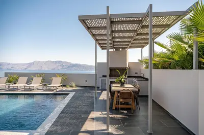 a patio with a table and chairs next to a swimming pool at Villa Thealon I New luxury villa with sea view and private infinity pool in Kissamos