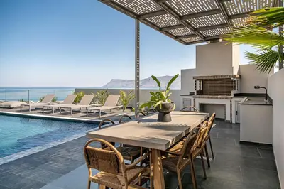 a dining room with a table and chairs and a pool at Villa Thealon I New luxury villa with sea view and private infinity pool in Kissamos