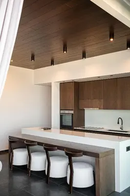 a kitchen with a large counter with chairs around it at Villa Thealon I New luxury villa with sea view and private infinity pool in Kissamos