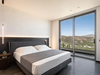 a bedroom with a large bed and a large window at Villa Thealon I New luxury villa with sea view and private infinity pool in Kissamos