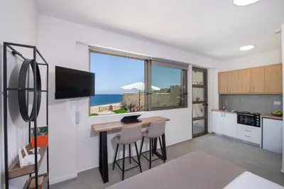 a kitchen with a table and chairs and a window at The Seaside Nest in Chania Town
