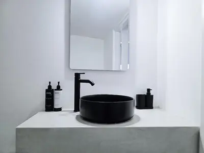 a bathroom with a black sink and a mirror at Suites with Shared Garden Sougia in Moní
