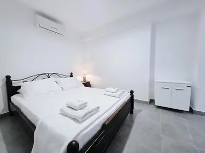 a bedroom with a bed with two towels on it at Suites with Shared Garden Sougia in Moní