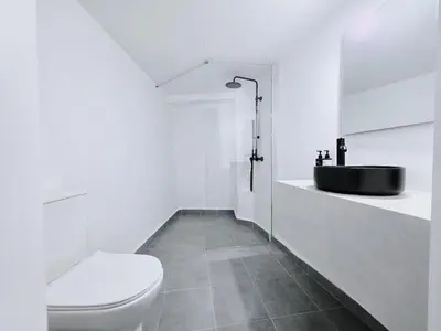 a bathroom with a black sink and a toilet at Suites with Shared Garden Sougia in Moní