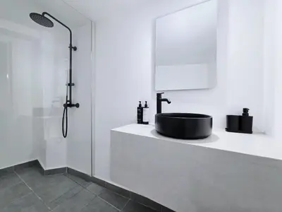 a bathroom with a black sink and a shower at Suites with Shared Garden Sougia in Moní